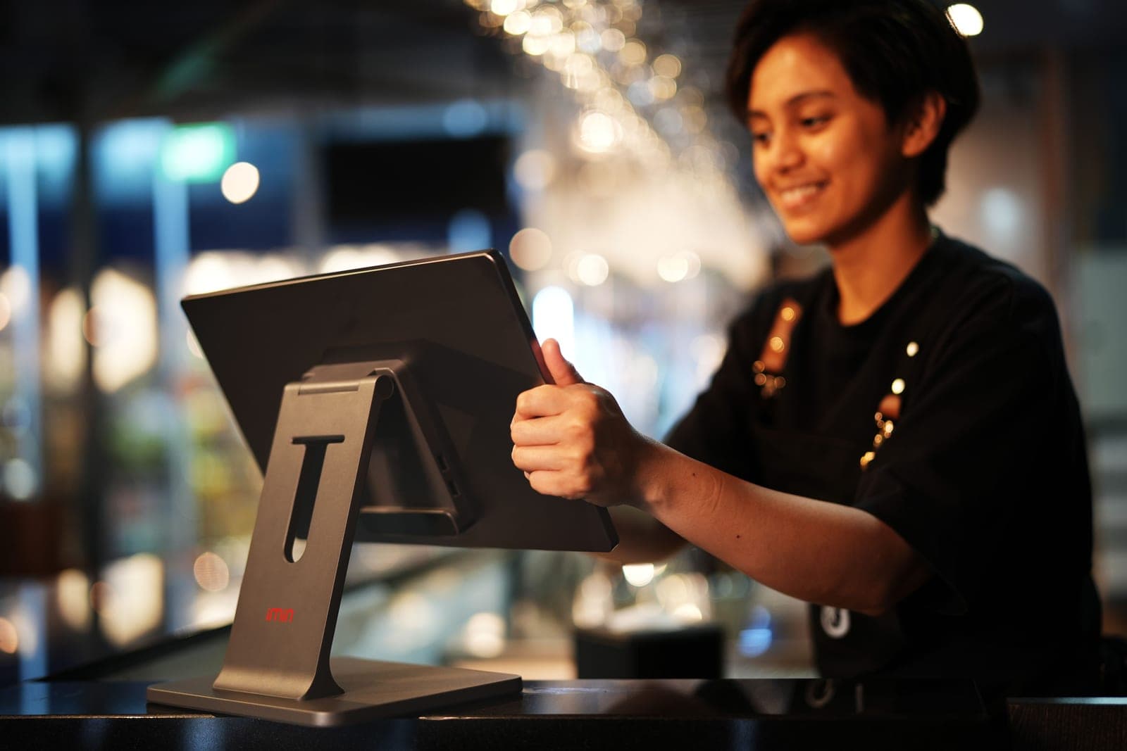 A restaurant host confirming a reservation on a tablet at the entrance